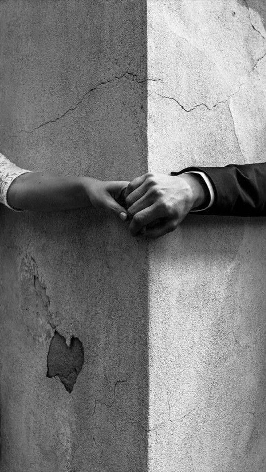 Manos apoyadas sobre un muro de hormigón agrietado, símbolo de poner límites sanos y sostener relaciones desde el respeto y la responsabilidad emocional. 