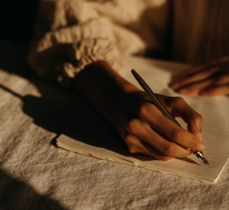 Persona escribiendo en un diario a mano, escritura expresiva.
